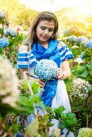 Beautiful Nicaraguan woman in national folk costume holding flowers in a nursery. Portrait of girl in traditional Central American folk costume holding flowers in a nursery. Nicaraguan folk costume photo