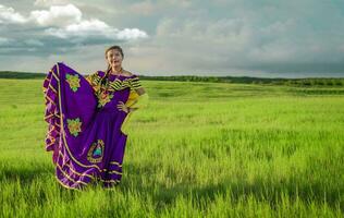 Portrait of Nicaraguan young woman in traditional folk costume in the field, Nicaraguan woman in traditional folk costume in the field grass photo