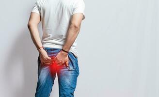 Person with hemorrhoid problem on isolated background, People with digestive problem touching his buttock, People with diarrhea problem photo
