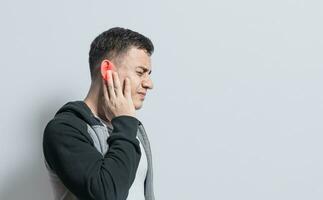 A person with otitis and tinnitus, Person with ear pain, on isolated background, Suffering man massaging his ear isolated photo