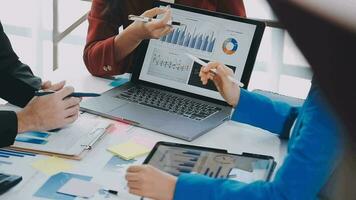 två kreativ företag människor möte och planera använda sig av posta den anteckningar klibbig notera på skrivbord till dela med sig aning, analys data Diagram och Graf med lagarbete strategi brainstorming i kontor. video