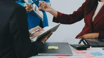 Two creative business people meeting and planning use post it notes sticky note on desk to share idea, Analysis data chart and graph with teamwork strategy brainstorming in office. video