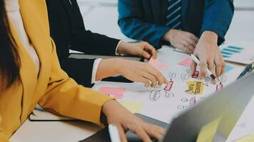 Two creative business people meeting and planning use post it notes sticky note on desk to share idea, Analysis data chart and graph with teamwork strategy brainstorming in office. video