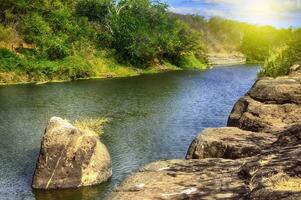 A river with rocks and blue sky, river surrounded by rocks with blue sky photo