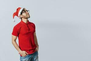 Christmas man with hand in pocket looking at copy space. Guy in Christmas hat with hands in his pocket looking at a promo, Christmas man with hands in his pocket looking at an advertisement photo
