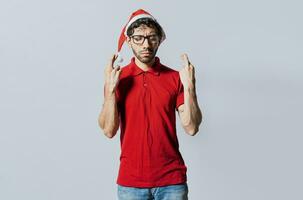 Handsome man in christmas hat making a wish on isolated background. Guy with christmas hat making a wish on isolated background, Hopeful man in christmas clothes making a wish photo