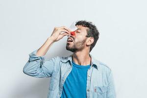 persona con irritado nariz en aislado fondo, hombre con rojo nariz frío, concepto de persona con sinusitis, persona con nasal congestión foto