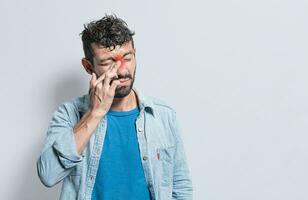 Person with pain touching nose. A person with nasal bridge pain, Man with nasal bridge headache. Sinus pain concept photo