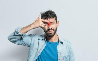 joven hombre con dolor conmovedor nariz. un persona con nasal puente dolor, hombre con nasal puente dolor de cabeza. seno dolor concepto foto