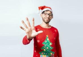 Man in christmas hat counting number five with fingers. Man in christmas costume counting number five with fingers. Concept of man in christmas costume counting number five isolated photo