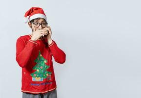 Man in christmas hat talking on the phone secretly. Christmas guy talking on the phone secretly, Christmas person talking on the phone secretly covering his mouth photo