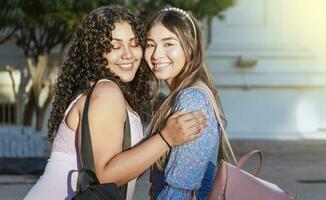 dos hembra amigos abrazando en frente al aire libre, niña amigos abrazando y disfrutando vida, mujer amistad concepto foto