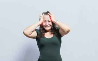 Woman with headache on isolated background, Concept of a person with a headache, Woman giving herself a head massage, Concept of a man with a migraine photo