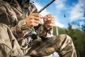 Fisherman Preparing Fish Bait on His Fishing Rod photo