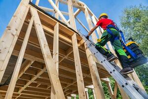 Construction Worker Climbing to Second Level Using Ladder photo