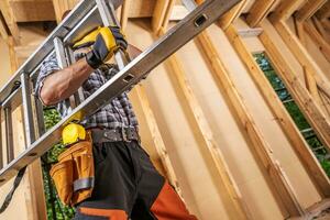 profesional construcción sitio trabajador Moviente escalera dentro un casa foto