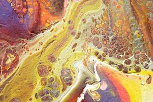 Spread-out acrylic paint. Abstract background, made in the technique of fluid art. Fashionable colorful background in warm colors photo