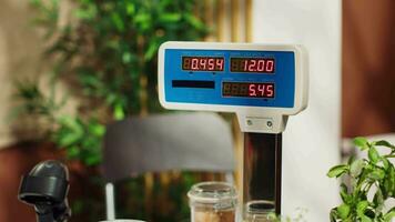 Close up of electronic scale in zero waste supermarket with low carbon dioxide emissions. Panning shot of weighing machine in local grocery store used for bulk products, fruits and vegetables video