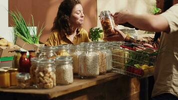 bruisend duurzame nul verspilling supermarkt liep door ouder winkelier assisteren paar. lokaal buurt kruidenier op te slaan vol met klanten boodschappen doen voor biologisch plaatselijk gegroeid produceren video