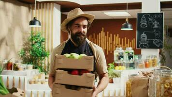 Storekeeper arriving in bio supermarket with freshly harvested locally grown food. Vendor restocks local neighborhood grocery shop with pesticides free vegetables and fruits video