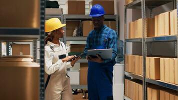 Two depot workers checking merchandise on shelves and planning order shipment or distribution, people looking at list of stock goods in warehouse. Products logistics and inventory. photo