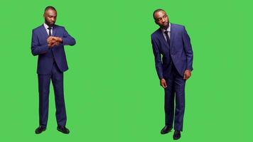 Young adult checking hour on wristwatch and waiting in studio, looking at clock before working on business company. Startup entrepreneur in suit posing with confidence in studio. photo