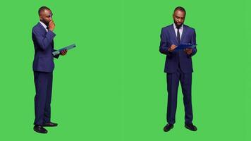 Startup manager thinking about new information on camera, brainstorming ideas and taking notes on clipboard files. Corporate employee wearing business suit and being thoughtful. photo