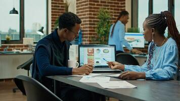 African american team making decisions to increase profit with executive management vision, meeting in boardroom office. Two employees discussing new analytics data, international startup. photo