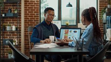 Business team discussing new strategy in boardroom office space, looking at data analytics on laptop. Brainstorming ideas to find startup development solutions, documents reports. photo