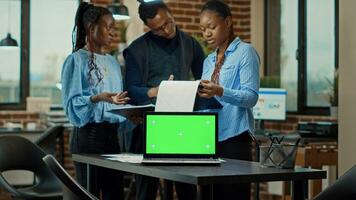 Business people using greenscreen and analyzing reports on files, coworkers checking chroma key display with copyspace. Examining isolated mockup template in boardroom meeting space. photo