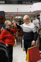 Sweet couple waltzing in retail store, moving around on music and enjoying romantic moment. Man and woman experiencing true love near customers at mall, doing dance moves on festive audio. photo