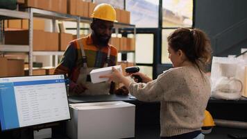 Young manager inspecting stock logistics in warehouse space, working on supply chain with inventory list on computer. Two diverse workers checking manufacturing service before shipping goods. photo