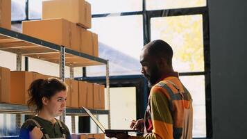 Warehouse team reviewing goods in packs, organizing products boxes before retail store orders for distribution. Diverse colleagues working in depot space, stock logistics. Handheld shot. photo