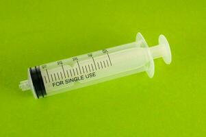 Disposable syringe on green background photo