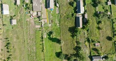 panoramic aerial view and flight over eco village with wooden houses, gravel road, gardens and orchards video