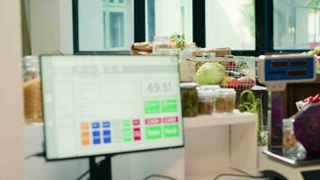 Low carbon footprint food in local supermarket, checkout counter with cash register used to purchase natural herbs or organic produce. Fruits, vegetables, grains, spices and pasta on display. video