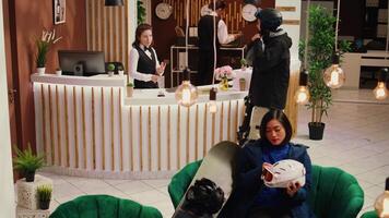 Employee greeting client at front desk, porter taking luggage from hotel guest to provide luxury service upon arrival. Person eager to go skiing on slopes at exclusive ski resort. Handheld shot. video