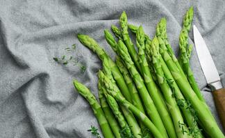 Fresh green asparagus on  textile background. photo