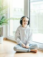 Cute little girl listening to music in headphones photo