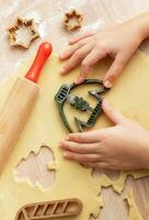 Children's hands with gingerbread cookies on wooden background photo