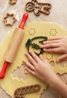 Children's hands with gingerbread cookies on wooden background photo