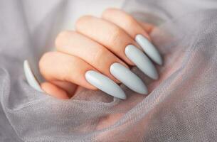 Grey nails on grey lace background. photo