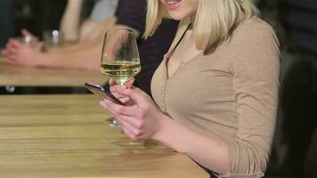 Close up of a young woman uses smartphone at the bar video