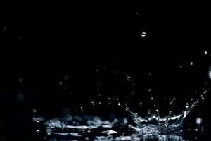 lluvia. agua gotas, salpicaduras en un negro antecedentes foto