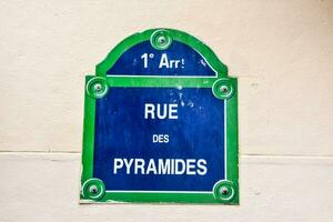 Blue street sign that says Rue Des Pyramides photo