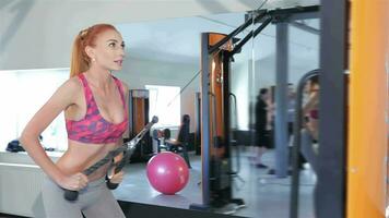 kvinna dragande de rep av Gym maskin till henne låren på de kondition Centrum video