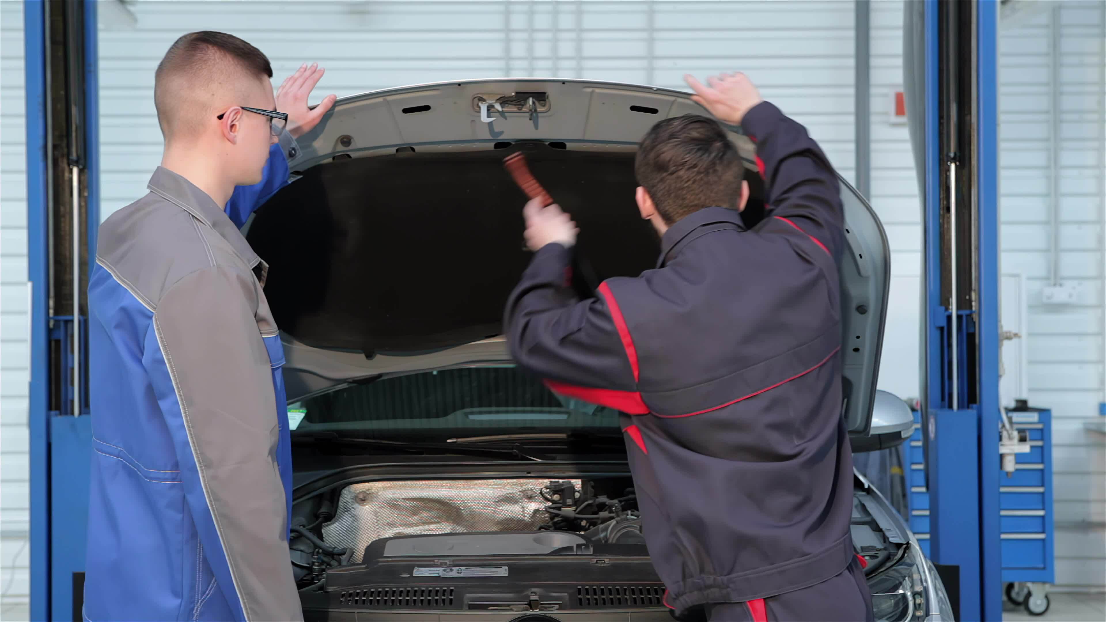 Two mechanics open the car hood at the car service 33876596 Stock Video at Vecteezy