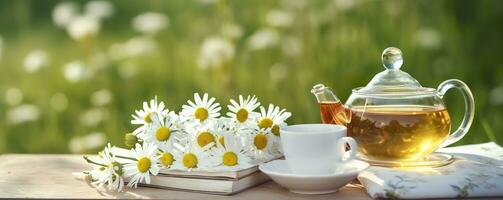 Chamomile flowers, books, a glass teapot, and a cup of herbal tea on a table closeup. Generative AI photo