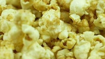 Slow motion and rotates popcorn. Yellow fresh salted popcorn texture circle rotation close up video