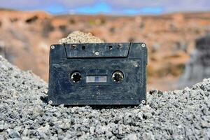 an old cassette sitting on top of some rocks photo